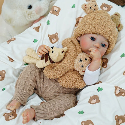 Side view of the reborn baby doll holding a teddy bear, with a peaceful expression.