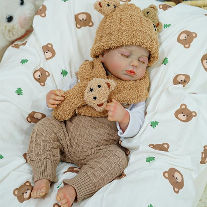 Reborn baby doll sleeping while holding a teddy bear.