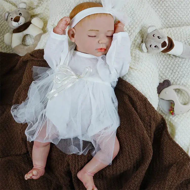 Reborn doll in delicate white tutu dress and headband.