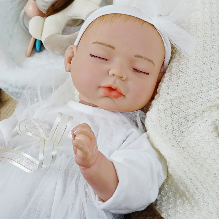Sleeping lifelike doll with elegant white gown.