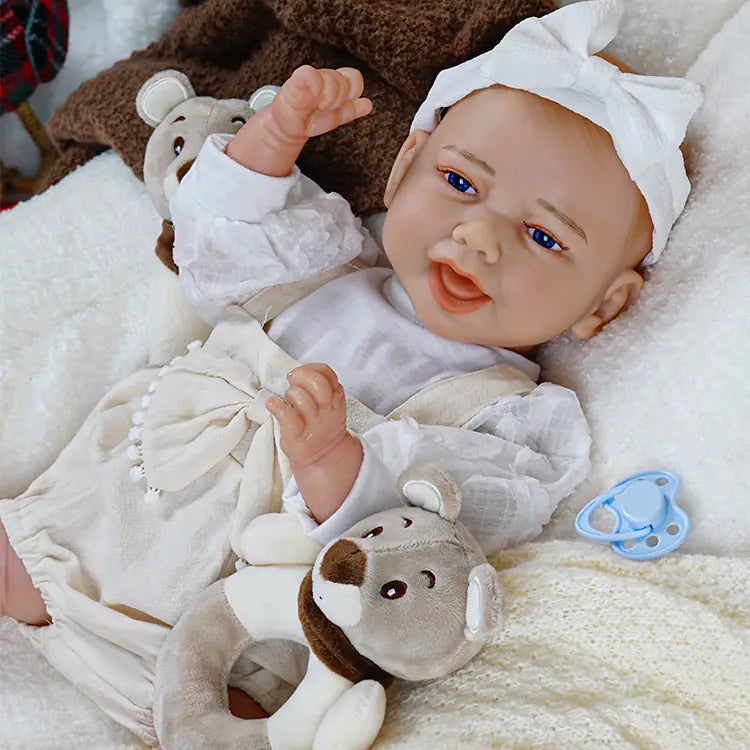 Joyful reborn baby doll in pink with two toy bears, waving a hand and smiling, ready to play