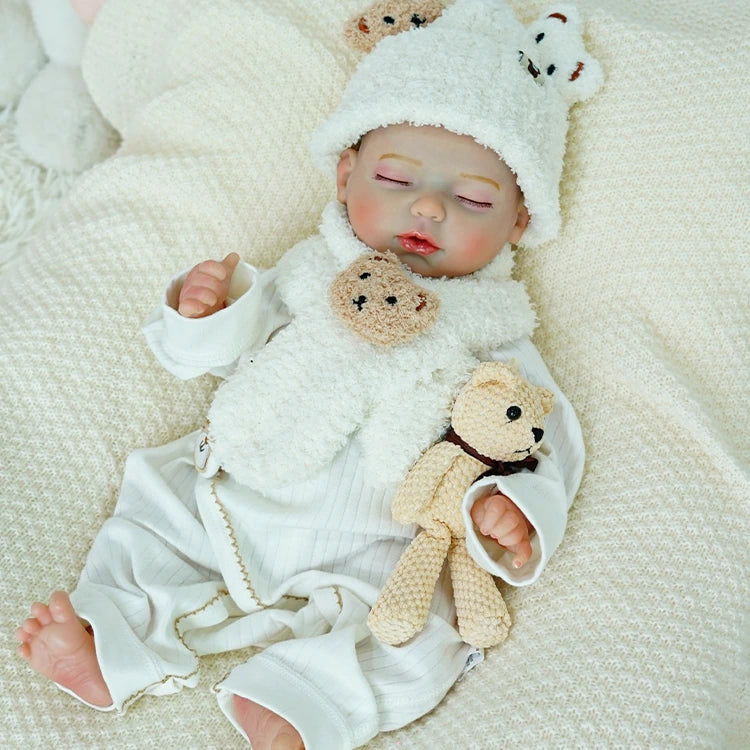 Reborn baby doll resting peacefully with a bear companion.