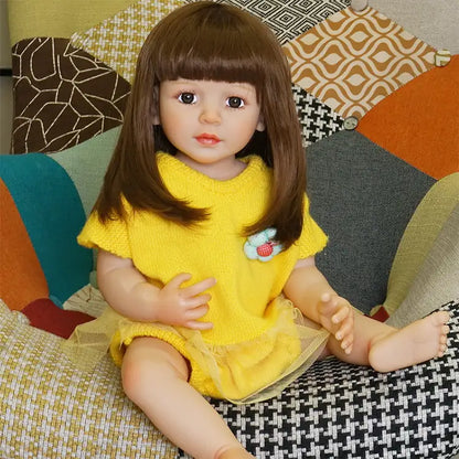 The doll is sitting on the same couch, slightly turned to the side, holding a small toy in her hand.