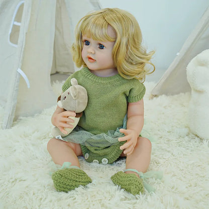 Reborn doll sitting on a fluffy carpet, wearing a green dress.