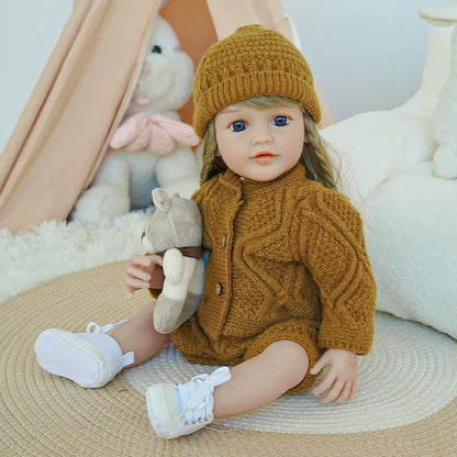 Close-up of reborn baby doll with blue eyes, in a brown knit outfit and hat.