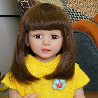 A close-up of the doll’s face and upper body, focusing on her facial features and the details of her yellow outfit.