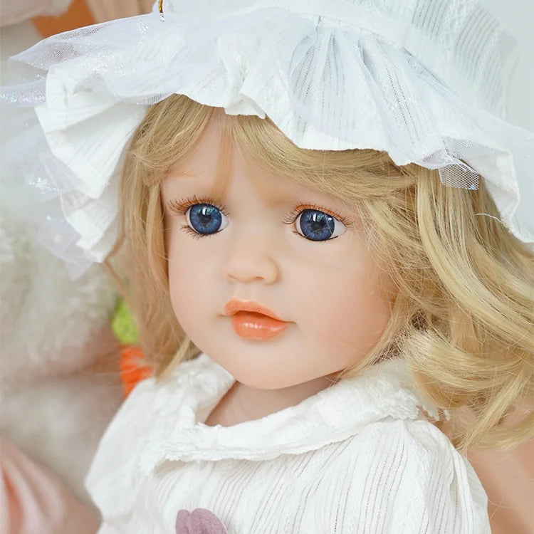 Chimidoll - Kleinkindpuppe, weißes Landoutfit, goldenes langes Haar, trägt einen Hut
