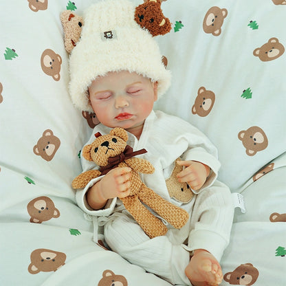 Reborn doll resting peacefully with a teddy bear.