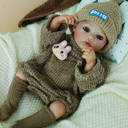 Reborn doll with a pacifier, wearing a knit hat and brown outfit.