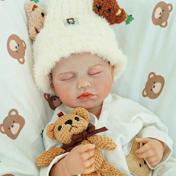 Reborn doll sleeping, cuddling the teddy bear.