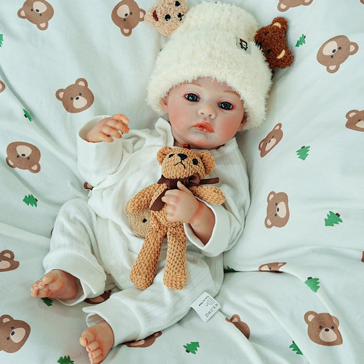 Reborn doll relaxing, embracing the teddy bear.