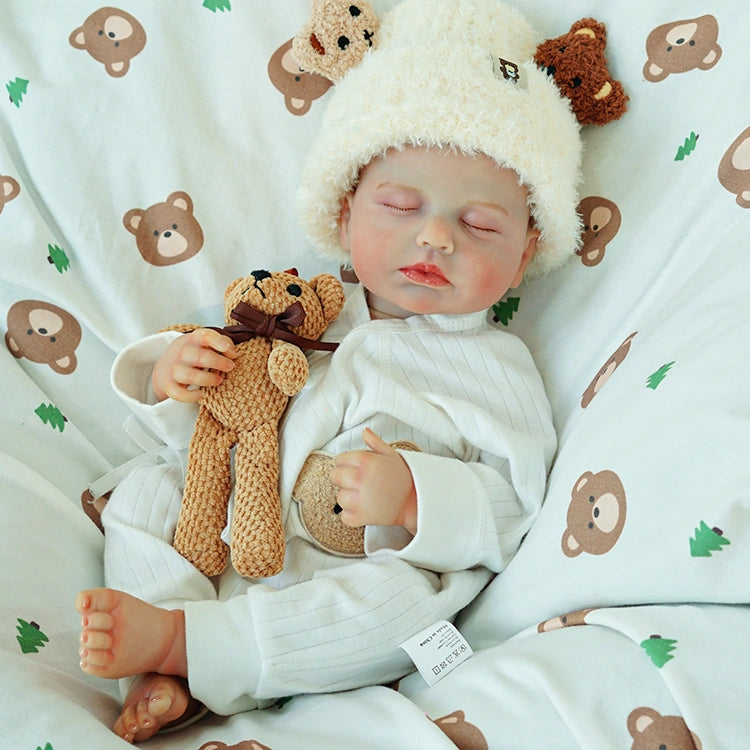 Reborn doll in a peaceful sleep with the teddy bear.