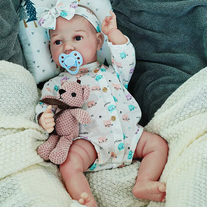 Close-up of the reborn baby doll's face, showing off the bow headband and detailed features.