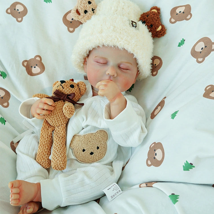 Doll holding a teddy bear while napping.