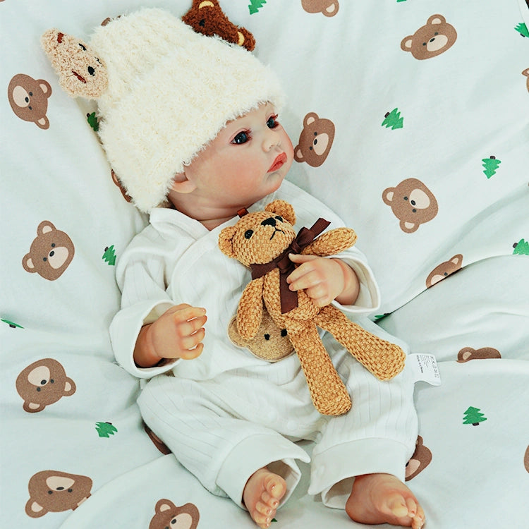 Reborn doll gazing thoughtfully with the teddy bear.