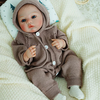 Reborn doll with lifelike features and soft knitted clothing.