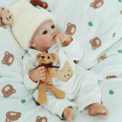 Reborn doll looking up while holding the teddy bear.