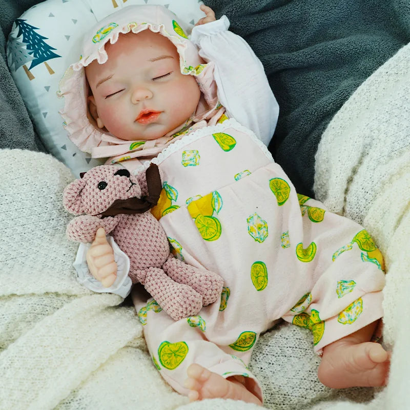 The reborn baby doll holding a pacifier in its mouth, dressed in a cute green-patterned onesie, lying with its knitted bear.