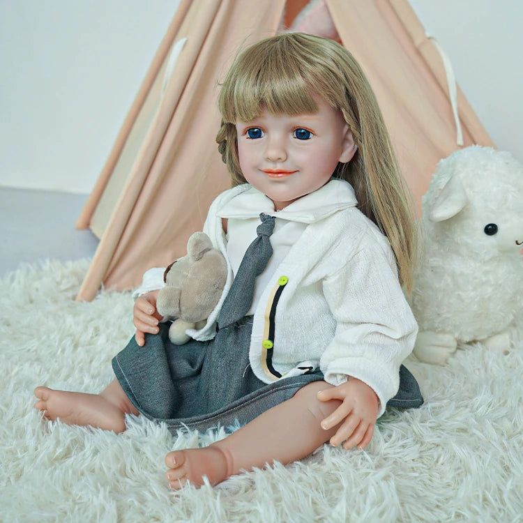 Reborn toddler doll smiling, sitting on a fluffy rug with a plush animal, dressed in a white shirt and gray skirt.