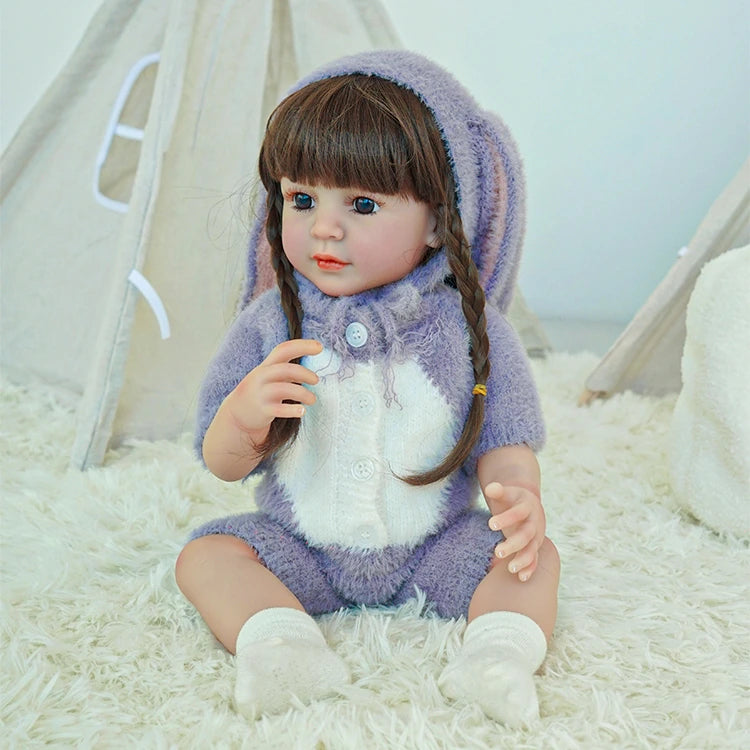 lifelike toddler doll with a purple bunny outfit and black long hair