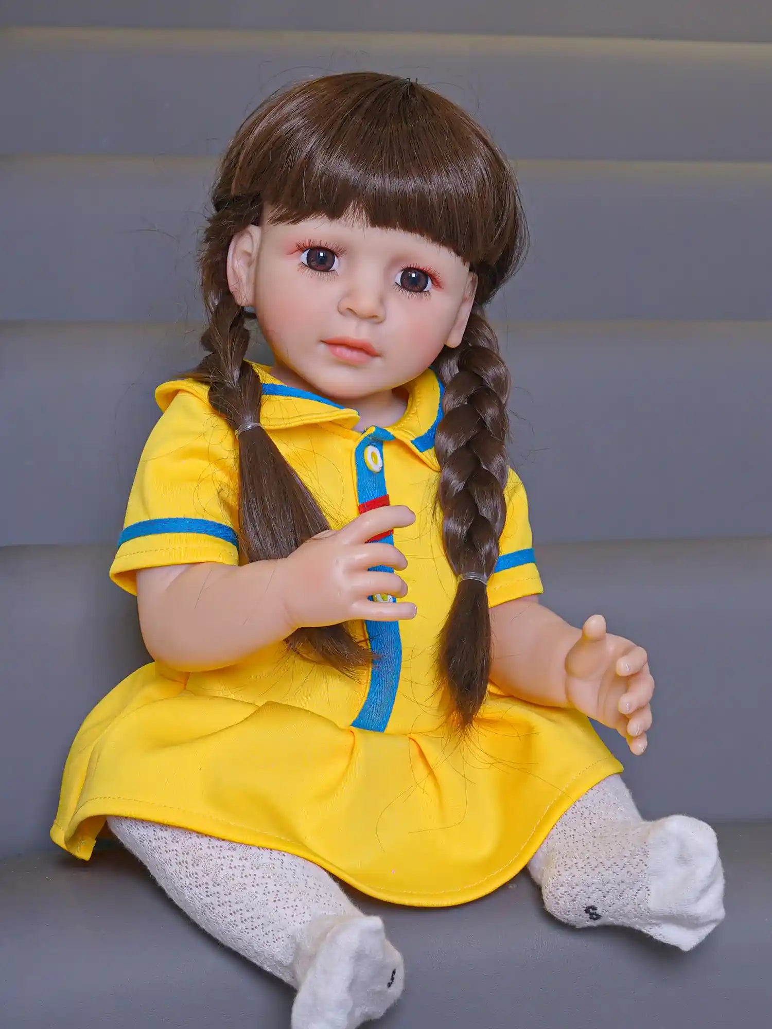 A charming doll featuring glossy braids, donning a yellow sporty dress, capturing the innocence of childhood in a nursery.