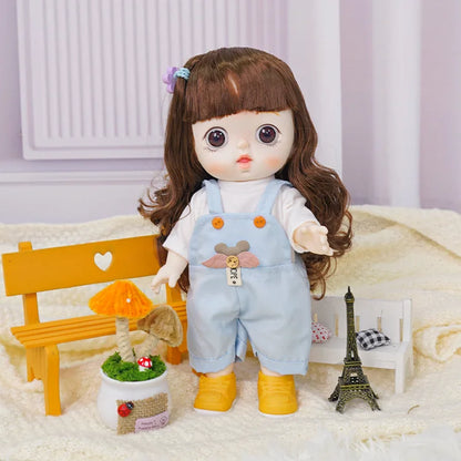 Doll with deep brown eyes and chestnut hair in a blue dungaree with a bear design, beside a miniature Eiffel Tower.