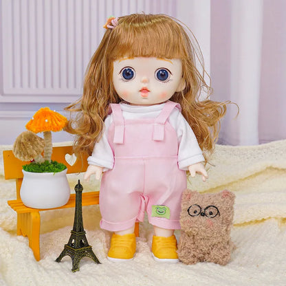 A doll with light brown hair and striking blue eyes wearing a pink pinafore over a white shirt, standing with a plush toy.