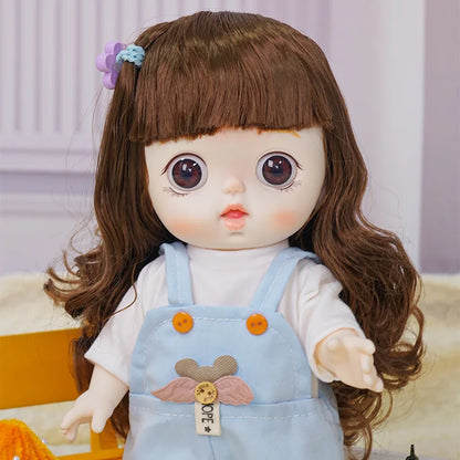 Toy doll with a whimsical look, dressed in light blue overalls and standing next to a tiny replica of the Eiffel Tower.