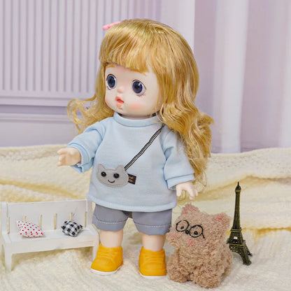 A golden-haired doll with a pink hair clip stands next to a plush animal and a miniature Eiffel Tower, evoking a Parisian theme.