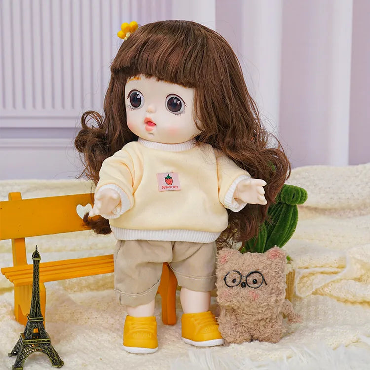 Doll with a soft, pastel-themed outfit and an animated expression, alongside a cute, bespectacled plush toy.